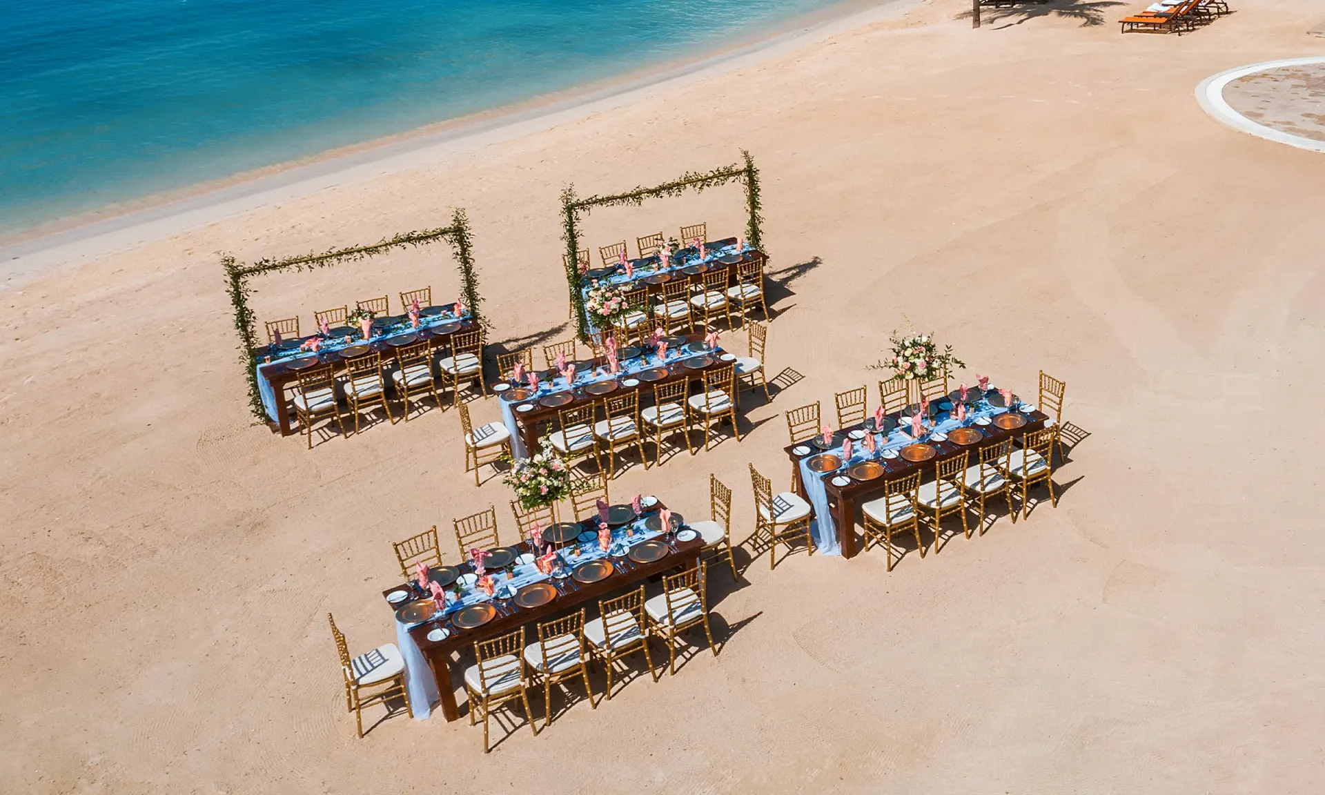 Overhead view of Jamaica wedding reception tables setting on the beach with tropical flowers